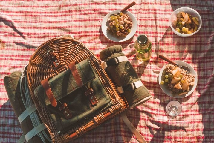 Wicker picnic basket with cutlery and blankets