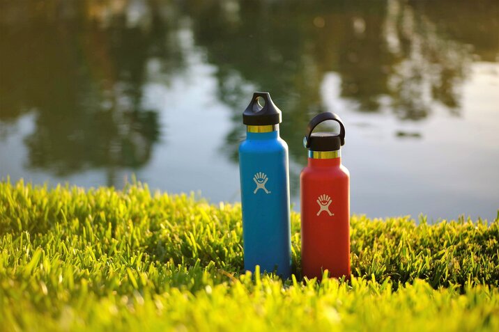 Blue and red water bottles on the grass