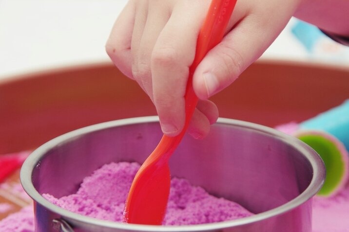 kid-play-with-pink-kinetic-sand