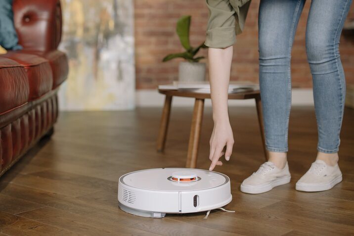 white robot vacuum on the wooden floor
